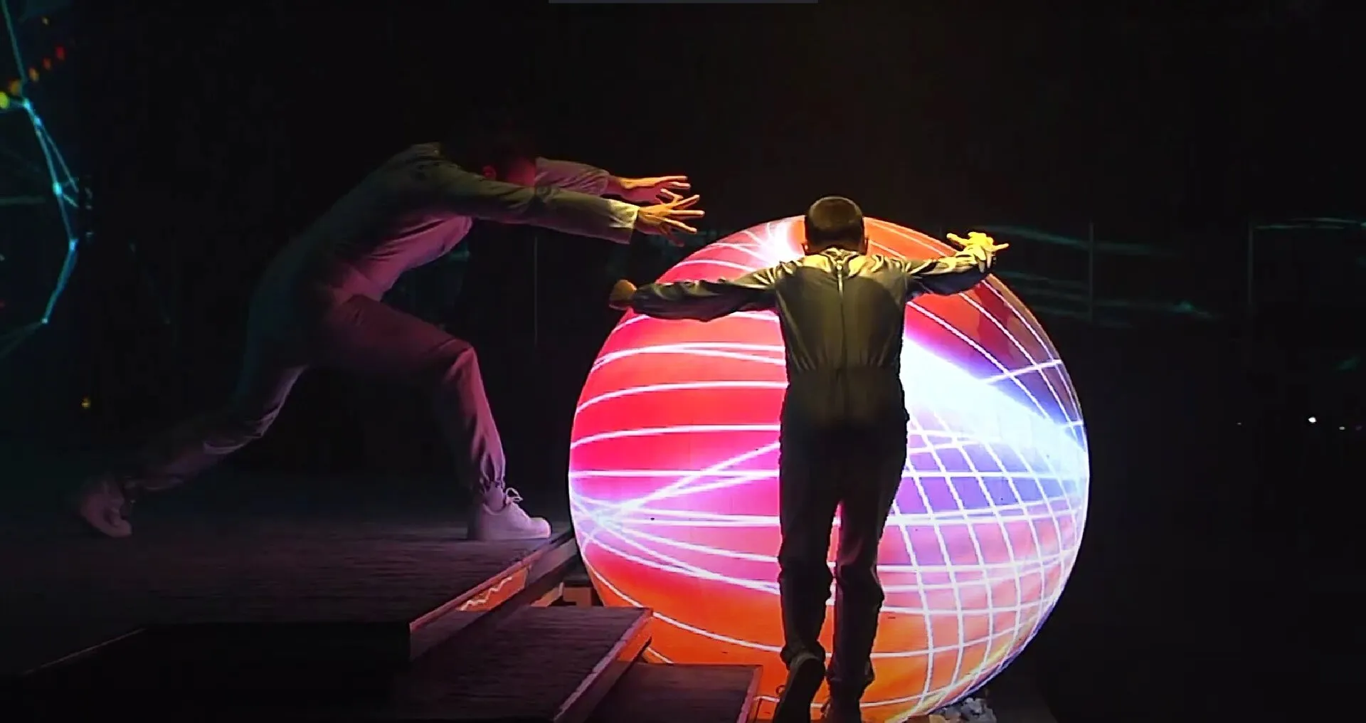 Performer silhouetted against a glowing projected sphere