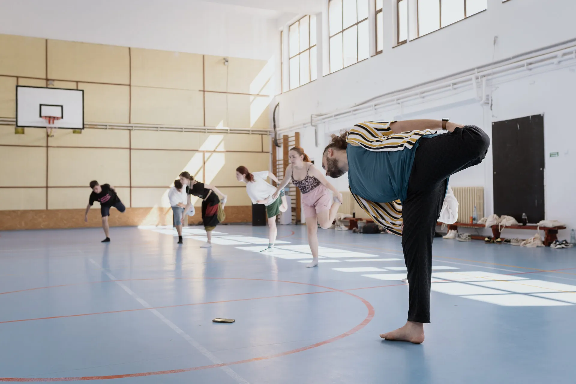 Filip Stoica demonstrating a floor-to-standing movement in a sports hall