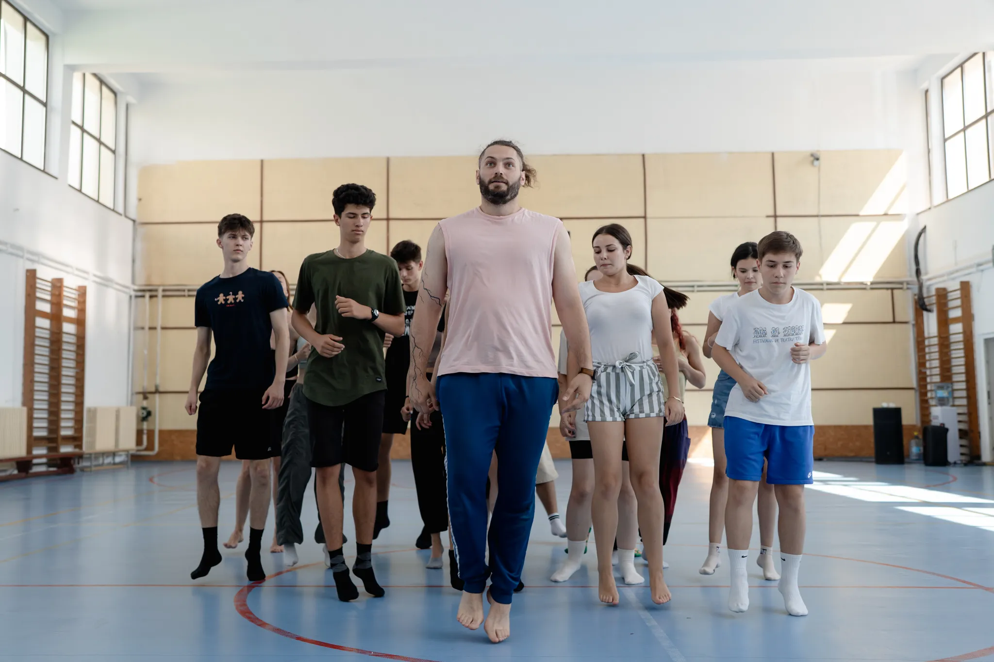 Filip Stoica leading a group of young dancers across a gym